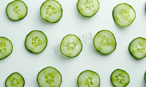 绿色沙拉摄影照片_白色背景中切片的新鲜绿色黄瓜