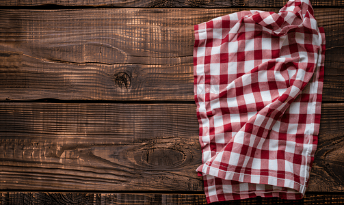 棕色木质背景上白色红色格子厨房毛巾
