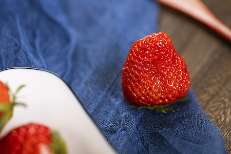 红草莓摄影照片_桌子上的一颗草莓特写图片