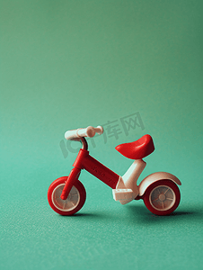 卡通卡通汽车摄影照片_绿色背景上的玩具自行车