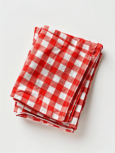 白色背景上折叠的棉质红白格子餐巾