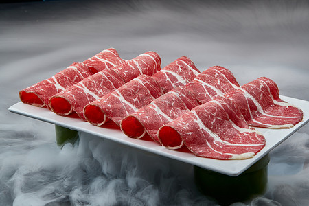 高级牛肉摄影照片_干冰缭绕的背景上摆放的高级雪花肥牛切片