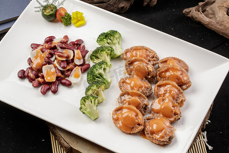 长方形瓷盘装的百合红豆浓汁薏米鲜鲍鱼摆放在樟木砧板上