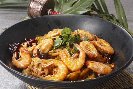 食品菜肴摄影照片_黑色陶盆装的麻辣香锅虾