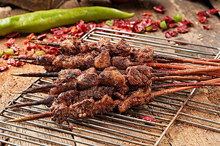 烤肉餐饮摄影照片_满是烟火气的烤炉上的鲜羊肉新疆红柳大串