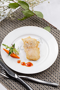 西餐精致美食摄影照片_日式铁板煎石斑鱼摆放在餐垫上