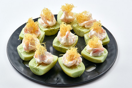美味的青黄瓜摄影照片_黑色瓷盘装的沙拉大虾仁