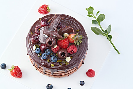 鲜奶巧克力摄影照片_蓝莓草莓车厘子巧克力鲜奶慕斯生日蛋糕