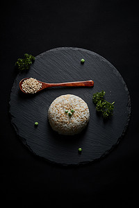 黑色青石板上摆放的燕麦米及蒸燕麦米饭
