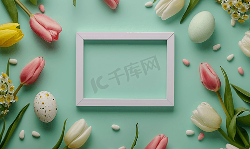 绿色背景中被复活节彩蛋和郁金香花包围的空白画框