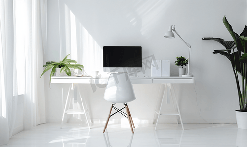白色家庭办公室中的白色桌椅、电脑显示器和现代文件柜
