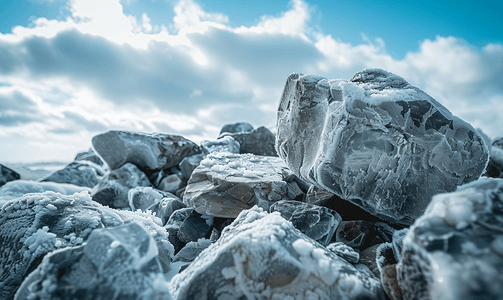 石头上的旧冰遗迹在云彩的天空下冰是灰色的垂直