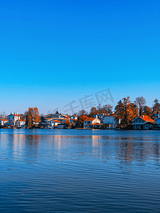 水桥城市摄影照片_清晨蓝天白云下湖边房屋的景色