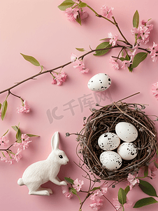 粉红色背景顶视图上有鹌鹑蛋和白色纸板兔子的快乐复活节巢穴