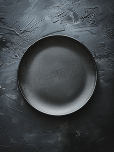 黑色背景顶视图上的空灰色圆形陶瓷板