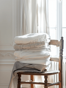 从顶部看明亮的房间木椅上堆放着自然色调的棉质上衣