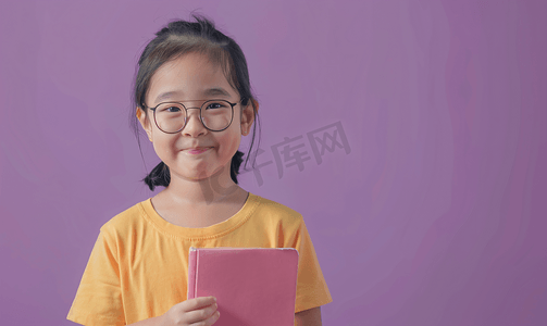 幸福约定字体摄影照片_紫色背景中亚洲儿童拿着书的画像
