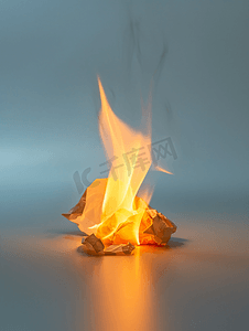电和纸燃烧摄影照片_燃烧的一张皱巴巴的纸