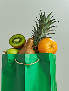 不同的果汁摄影照片_绿色购物袋里面有不同的水果菠萝、香蕉、橙子、猕猴桃和苹果