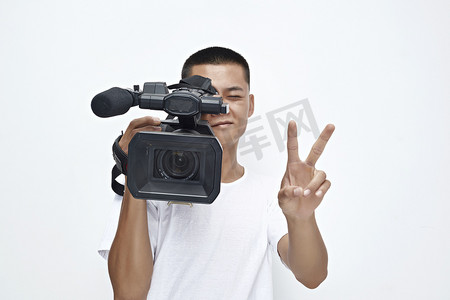 电影机摄影照片_白色背景下手持摄像机进行录制拍摄的摄像师