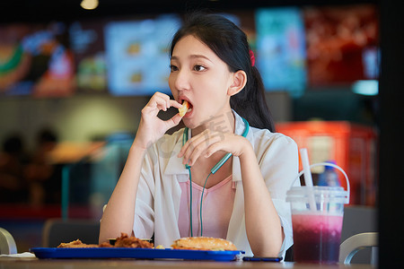 在商场快餐厅大吃特吃的中国可爱少女人像