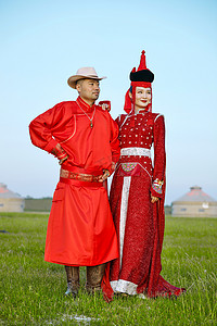 双人模特摄影照片_草原上蒙古包前穿蒙古族传统服饰的年轻夫妻