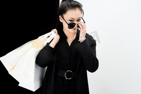 黑白色背景下的手提购物袋的时尚亚洲少女