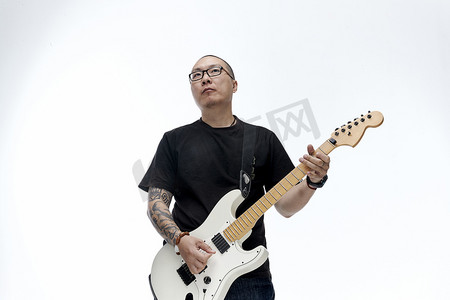 律动声势摄影照片_手持电吉他展示演奏的亚洲男性摇滚乐手人像