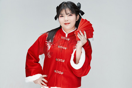 冬季红色喜庆摄影照片_白色背景下身穿喜庆汉服手拿红包的可爱少女