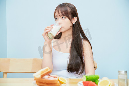 美丽的少女在餐桌前吃早餐