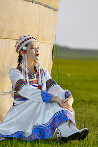 迎接晨光摄影照片_草原上穿着蒙古族传统服饰的亚洲年轻美少女