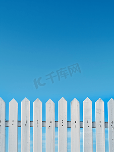 美丽村庄摄影照片_白色木栅栏和湛蓝的天空背景