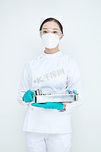 身穿护士服手抱化验托盘的年轻女护士