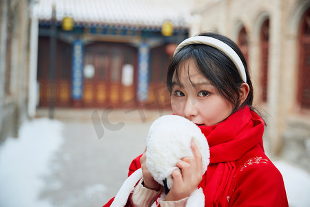 老城建筑摄影照片_雪后在老城古巷穿着喜庆服饰的亚洲少女