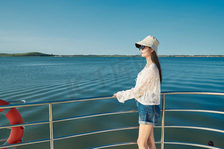 波浪夏日摄影照片_夏日在游艇观光平台上的亚洲少女