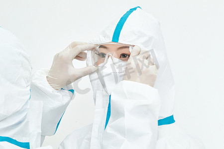 施工安全图摄影照片_穿白色防护服佩戴护目镜口罩的女性医疗人员