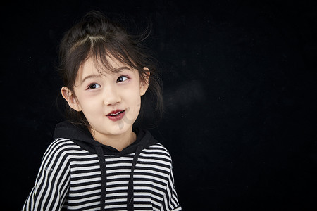 黑色背景的调皮可爱的亚洲小女孩儿童