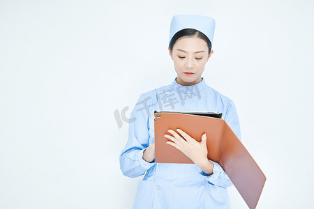 怀抱背景摄影照片_身穿护士服手拿医用iPad的年轻护士