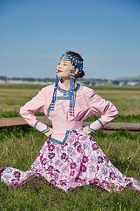 蒙古包前穿蒙古族饰怀抱奶茶桶的蒙族少女