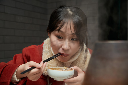 北京老火锅摄影照片_在饭店吃传统铜锅涮肉的亚洲少女