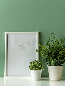 空的白色木制相框和白桌绿色背景上有植物的花盆