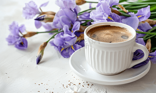 一杯咖啡放在碟子上旁边是一束紫色鸢尾花
