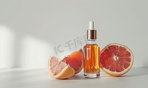 白色纹理背景上装有油和葡萄柚的滴管瓶