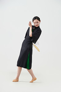免扣扇子摄影照片_穿着中式旗袍翩翩舞蹈的亚洲少女舞者