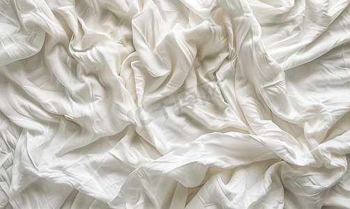 背景床单摄影照片_白色皱巴巴的床罩柔软的织物纹理背景