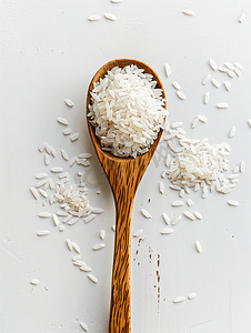 白色背景上木勺中的米饭顶视图白色长粒未煮过的生米的质地