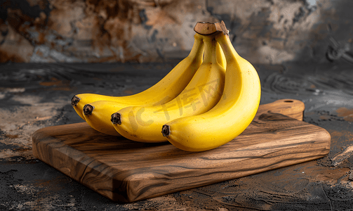 厨房水果背景摄影照片_木制厨房板上放着一堆新鲜成熟的黄香蕉
