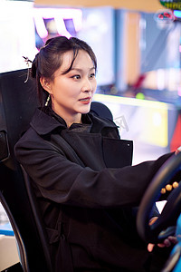 周末在电子游戏娱乐玩赛车游戏的美女