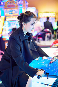 周末在电子游戏娱乐城玩摩托车游戏的美女