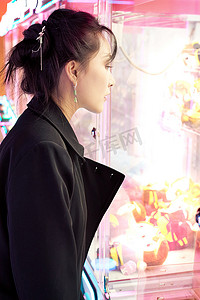 在娱乐城玩抓娃娃机的美女